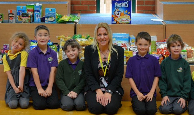 Schoolchildren present food bank with harvest collection