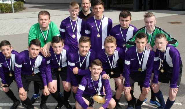 Players lift schools football trophy 